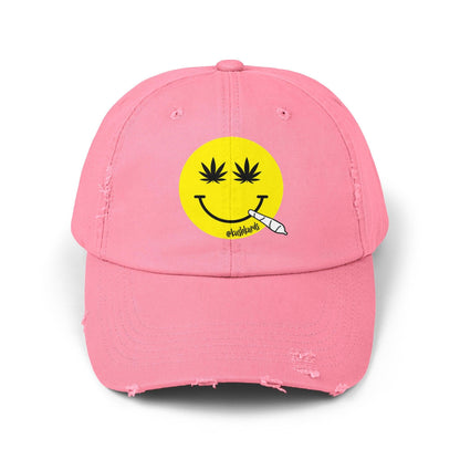 Nice Jay Smiley Face Distressed Dad Hat featuring a playful yellow smiley face with cannabis leaves for eyes and a rolled joint in the mouth, on a pink cotton twill cap.