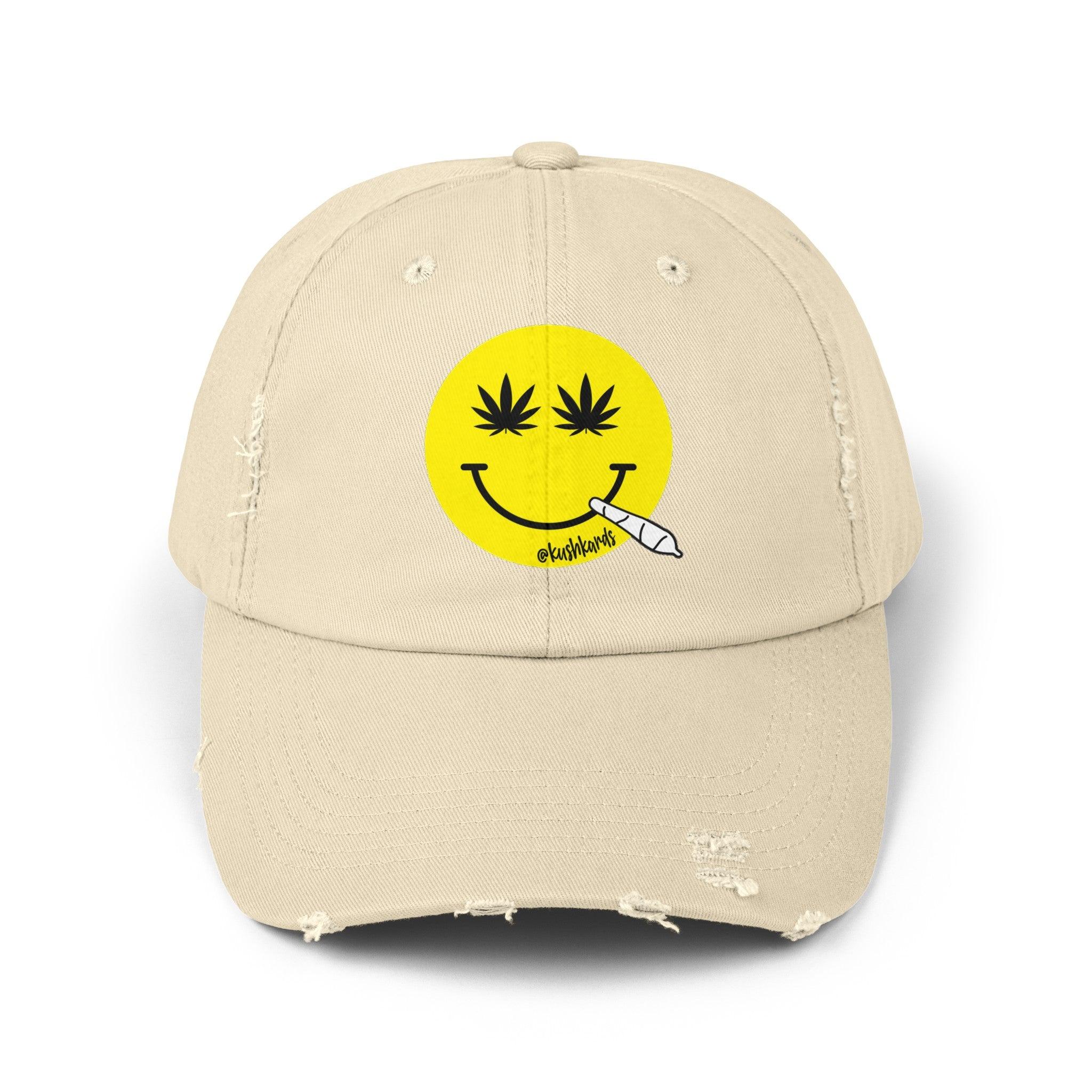 Nice Jay Smiley Face Distressed Dad Hat featuring a playful yellow smiley face with cannabis leaves for eyes and a rolled joint in the mouth, on a stone colored cotton twill cap.