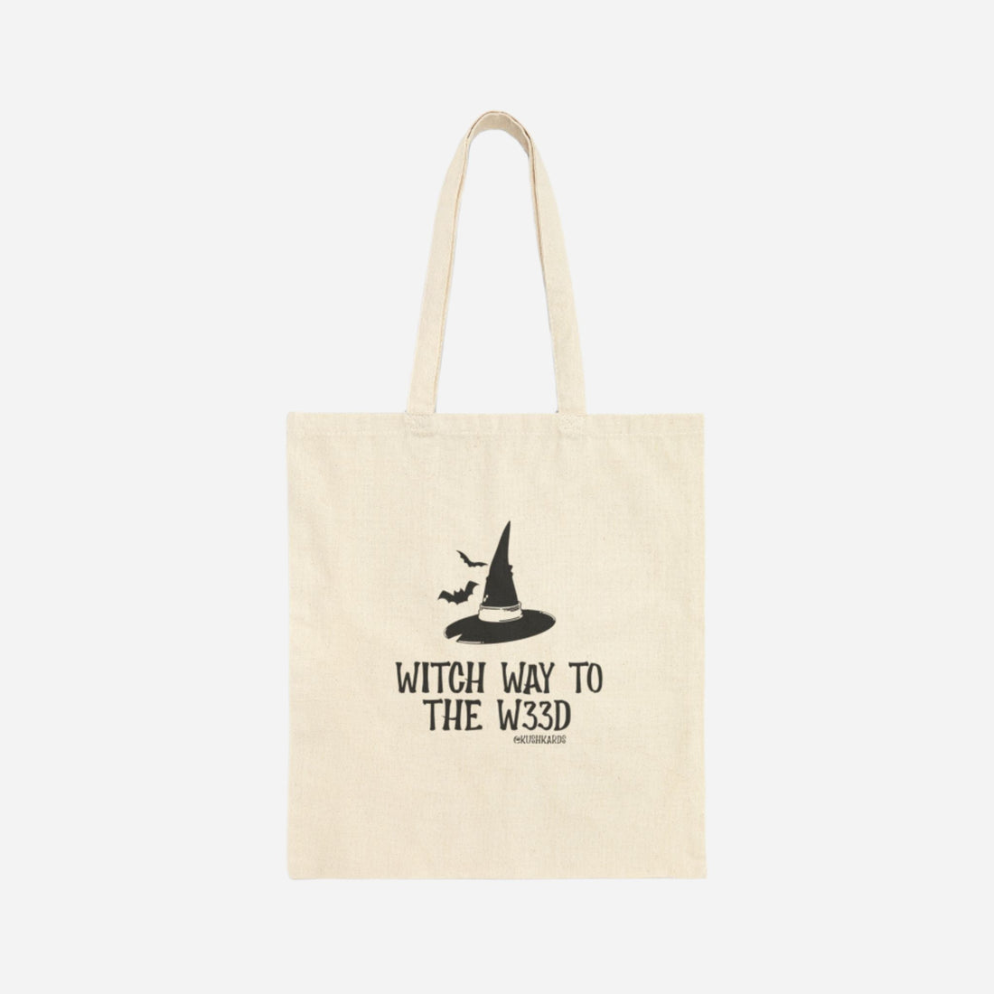 Front of the Witchy Tree Cotton Canvas Tote Bag featuring a black witch hat and bats with the phrase &quot;Witch Way to the W33D.&quot;