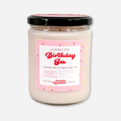 A clean product shot of the &quot;Birthday Sex&quot; soy wax candle in a glass jar with a black lid. The label highlights the funfetti cake and vanilla scent with a 90-hour burn time and 100% soy wax formula.