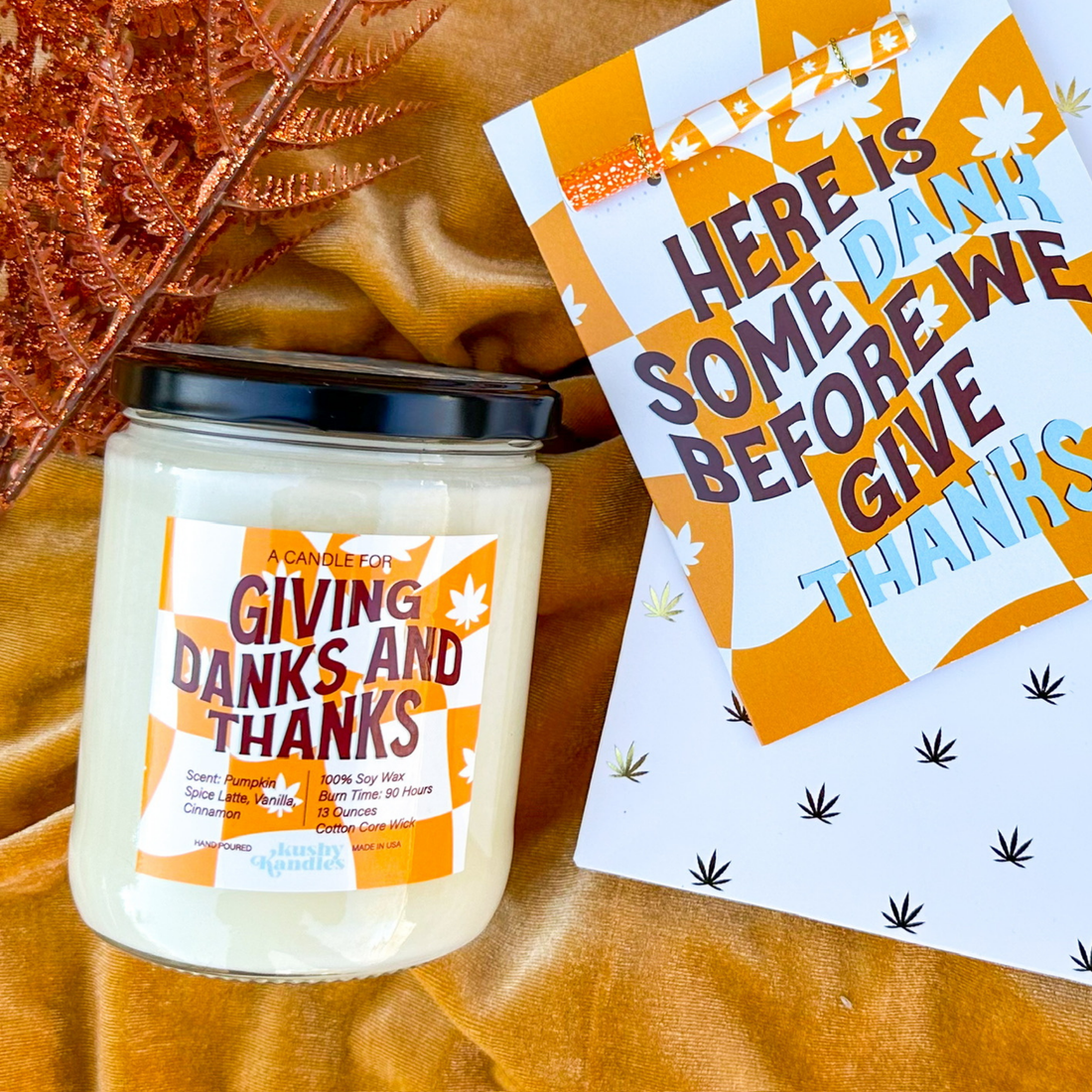 A Giving Danks &amp; Thanks soy wax candle with pumpkin spice scent, displayed on a warm autumn backdrop alongside a fun Thanksgiving-themed card.