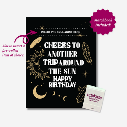 Celestial-themed birthday card with the text &quot;Cheers to Another Trip Around the Sun Happy Birthday,&quot; featuring a slot to insert a pre-rolled item, with an included matchbook displaying the brand name &quot;KushKards puff puff pass.&quot;