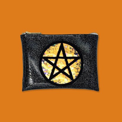 The Witch Way To The Weed Pot Leaf Midi Kush Klutch is a handbag that is 7&quot;x5&quot; in a black glitter vinyl with a pentagram symbol on it. Behind the pentagram is an orange pot leaf confetti encased in vinyl.